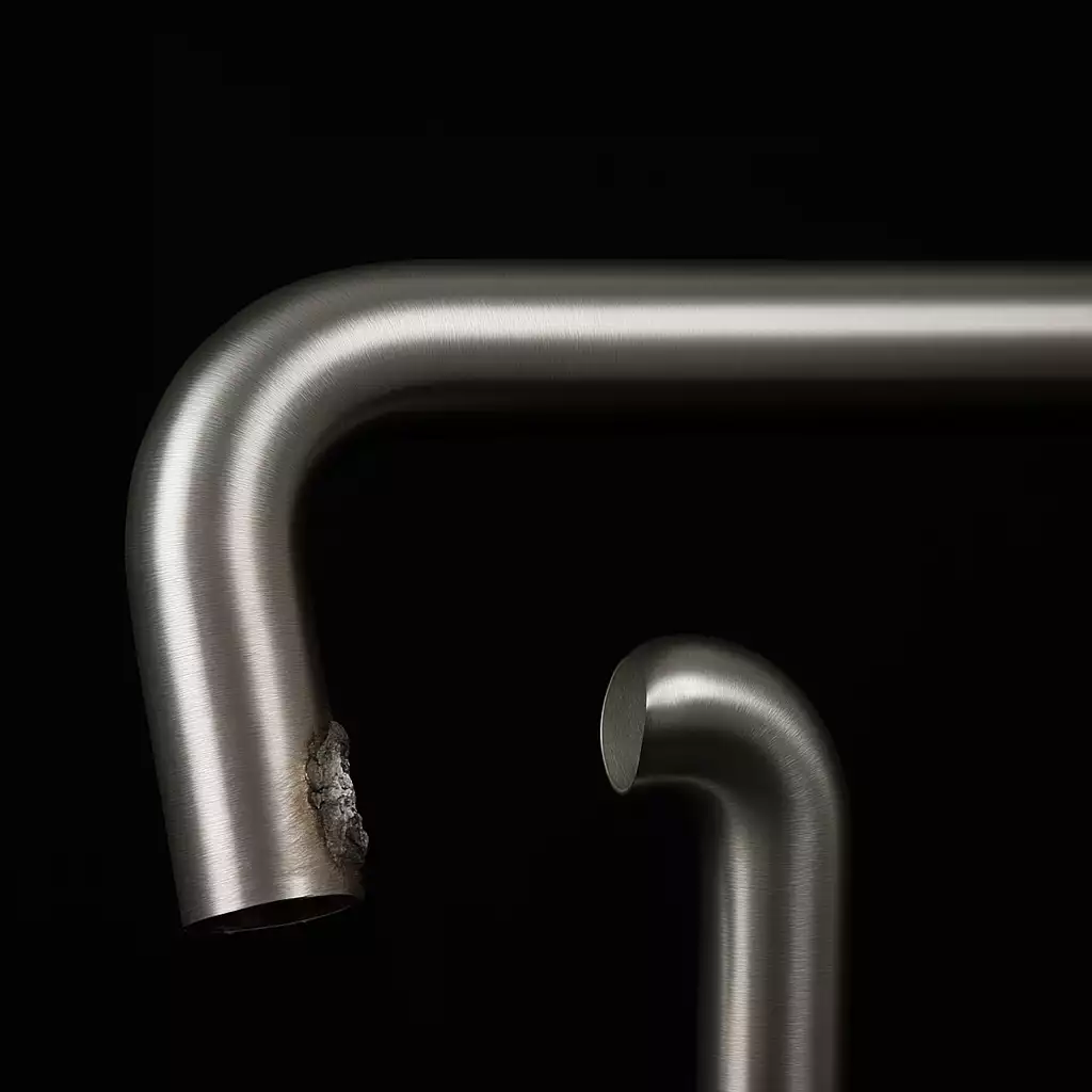Detalhe de curva e solda em tubo de aço inox escovado