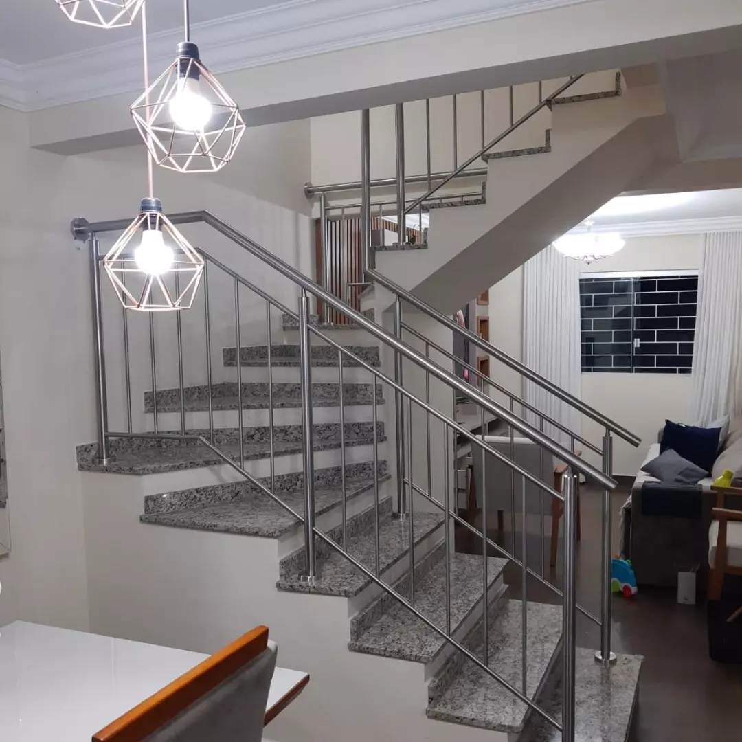 Corrimão de aço inox com guarda-corpo instalado em escada residencial