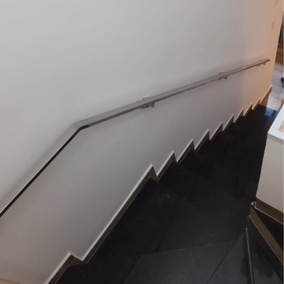 Corrimão de aço inox em escada interna com degraus de granito